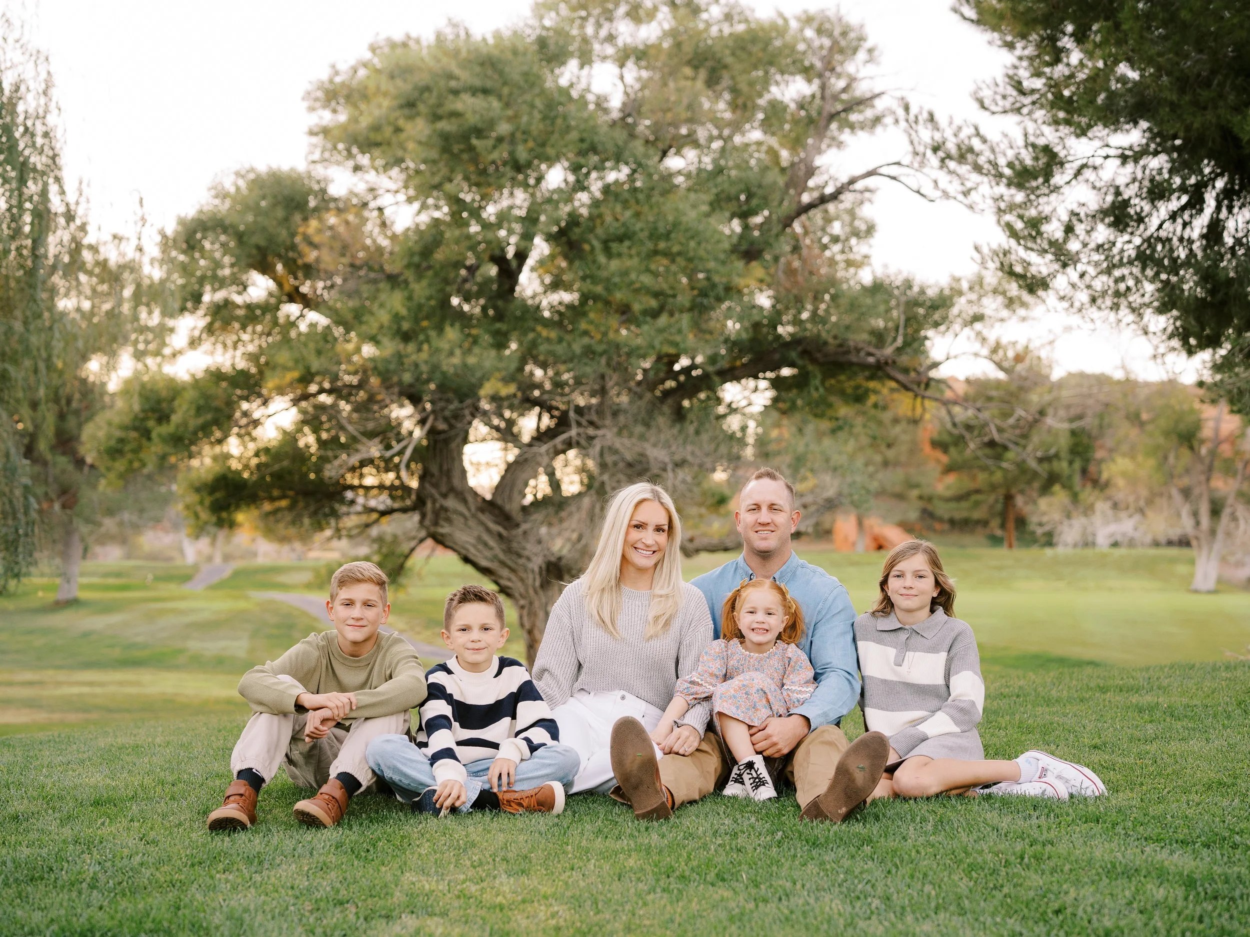 Family sitting close together on a blanket on the lawn
