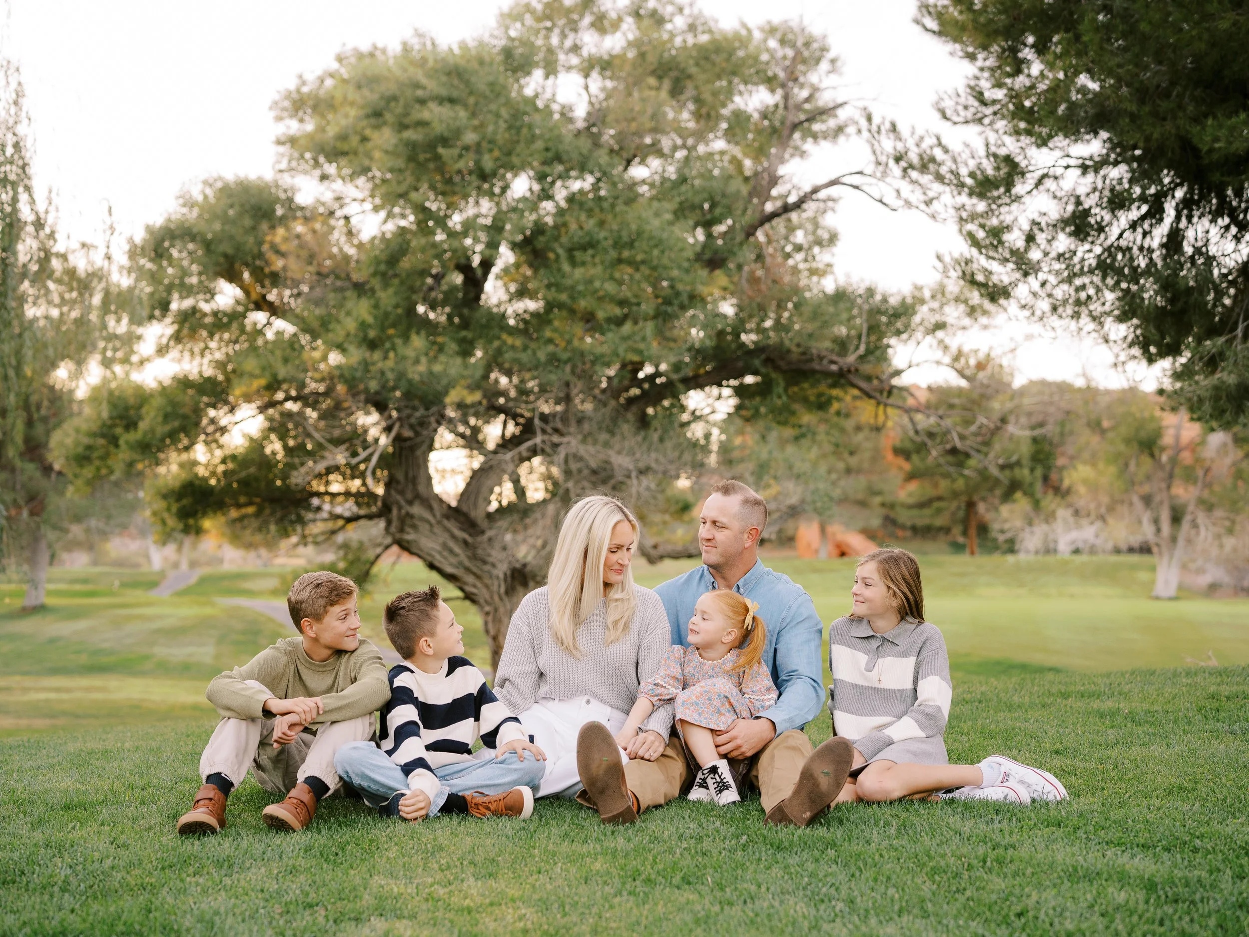 Parents and children seated on a blanket, turning toward one another