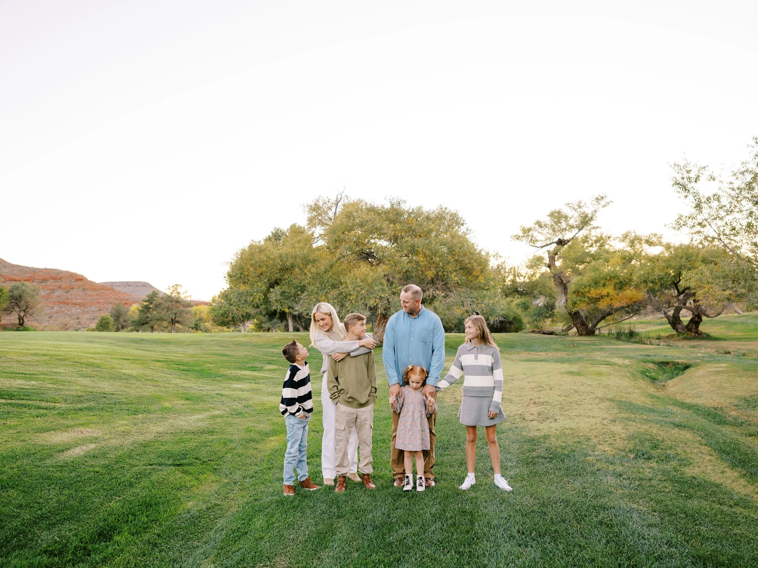 Wide view of the family walking together across the green lawn