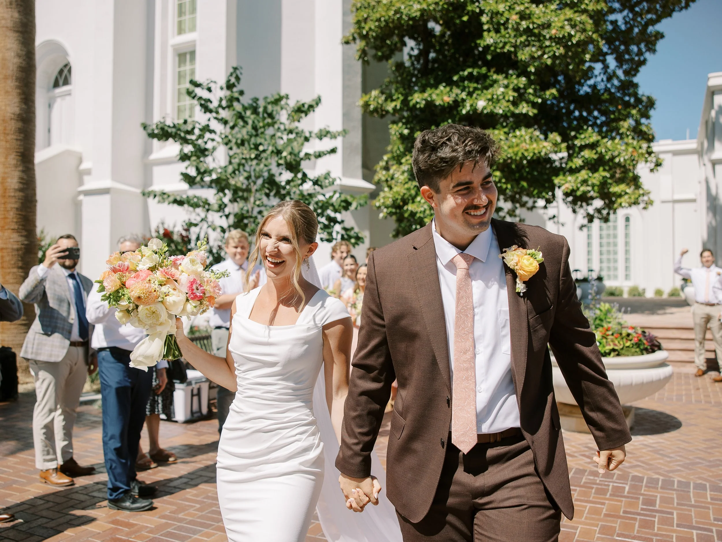 Abby holding her colorful bouquet as she walks beside Noah