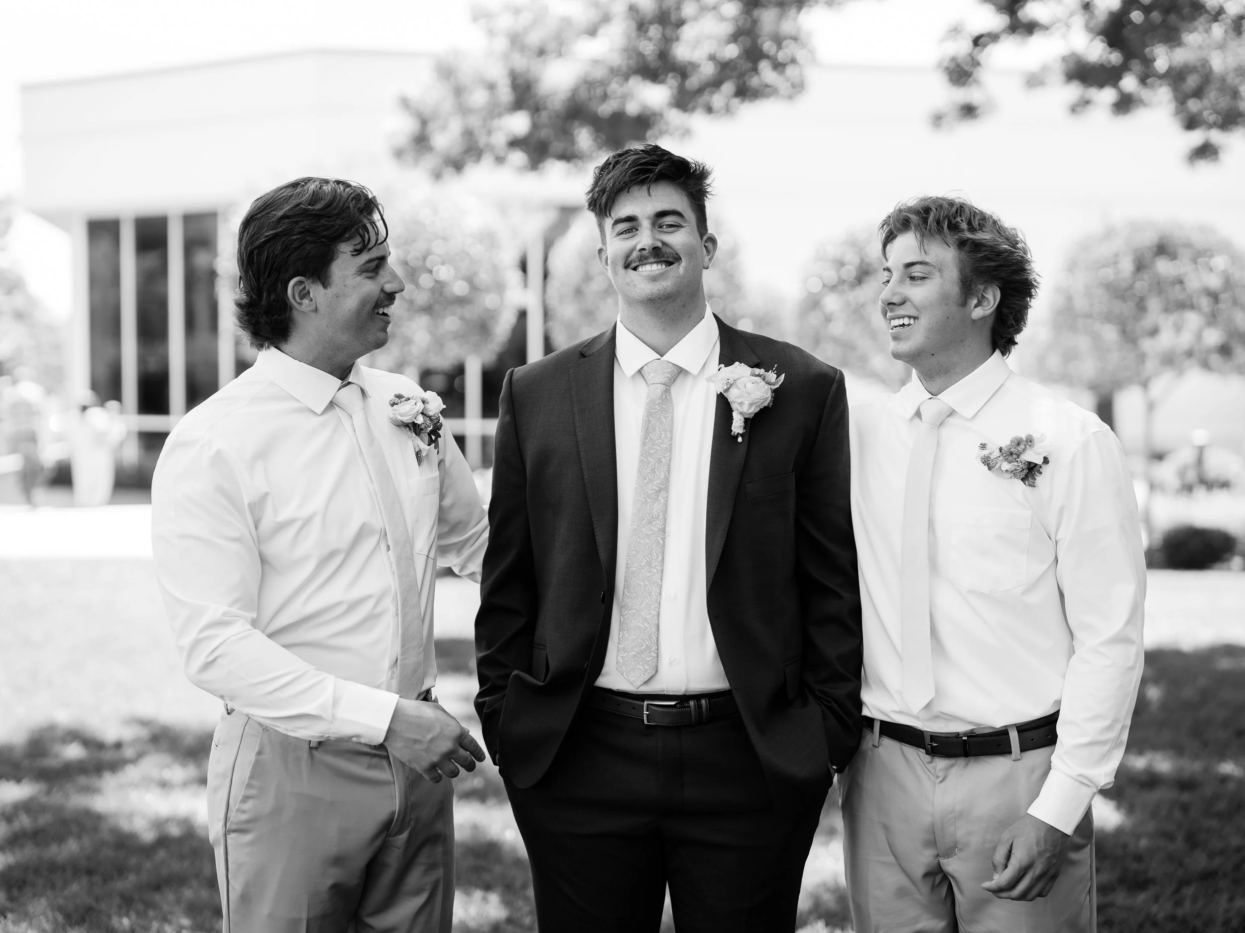 Black and white portrait of Noah laughing with his groomsmen