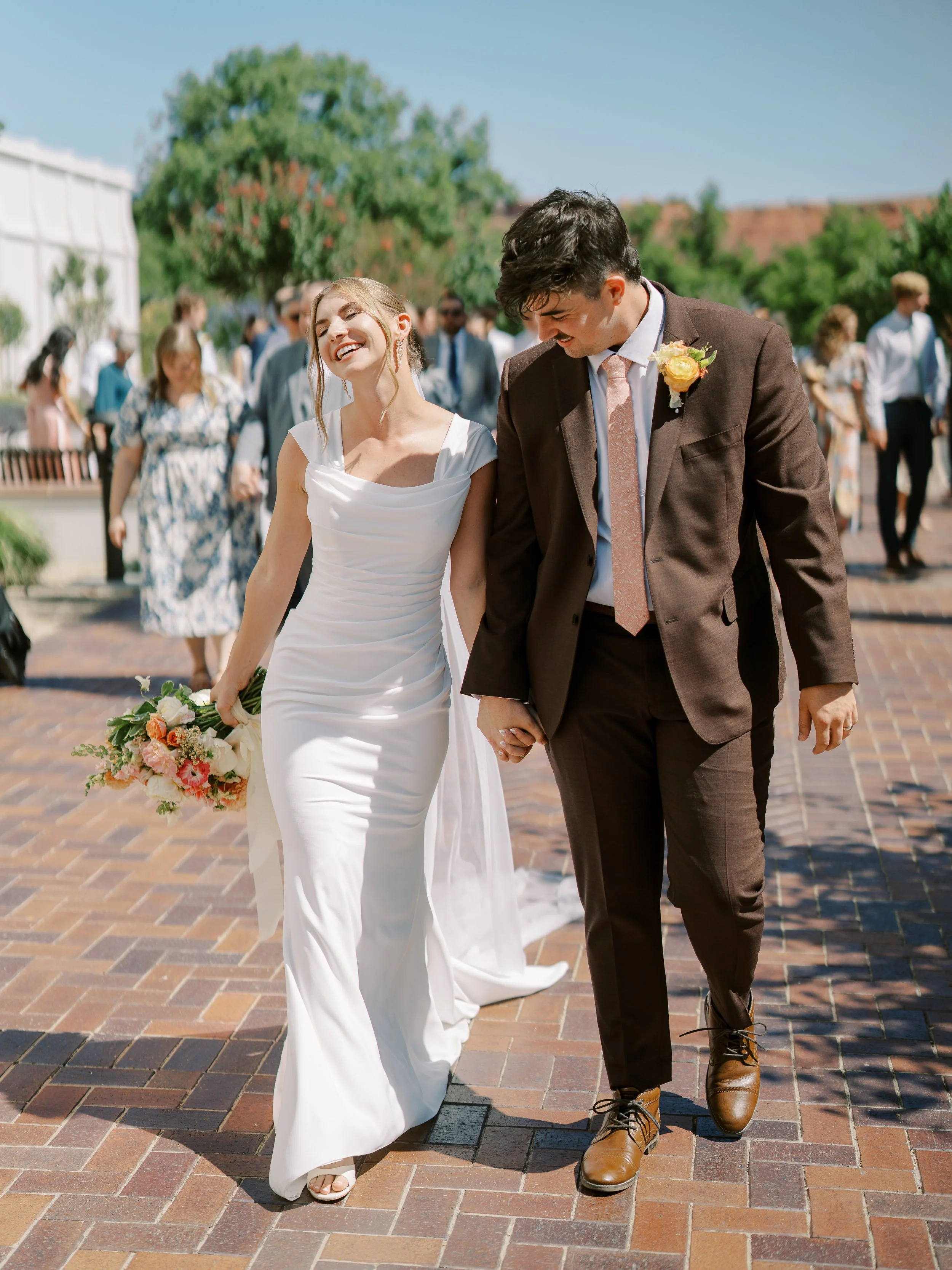 Abby and Noah walking hand in hand after their temple wedding