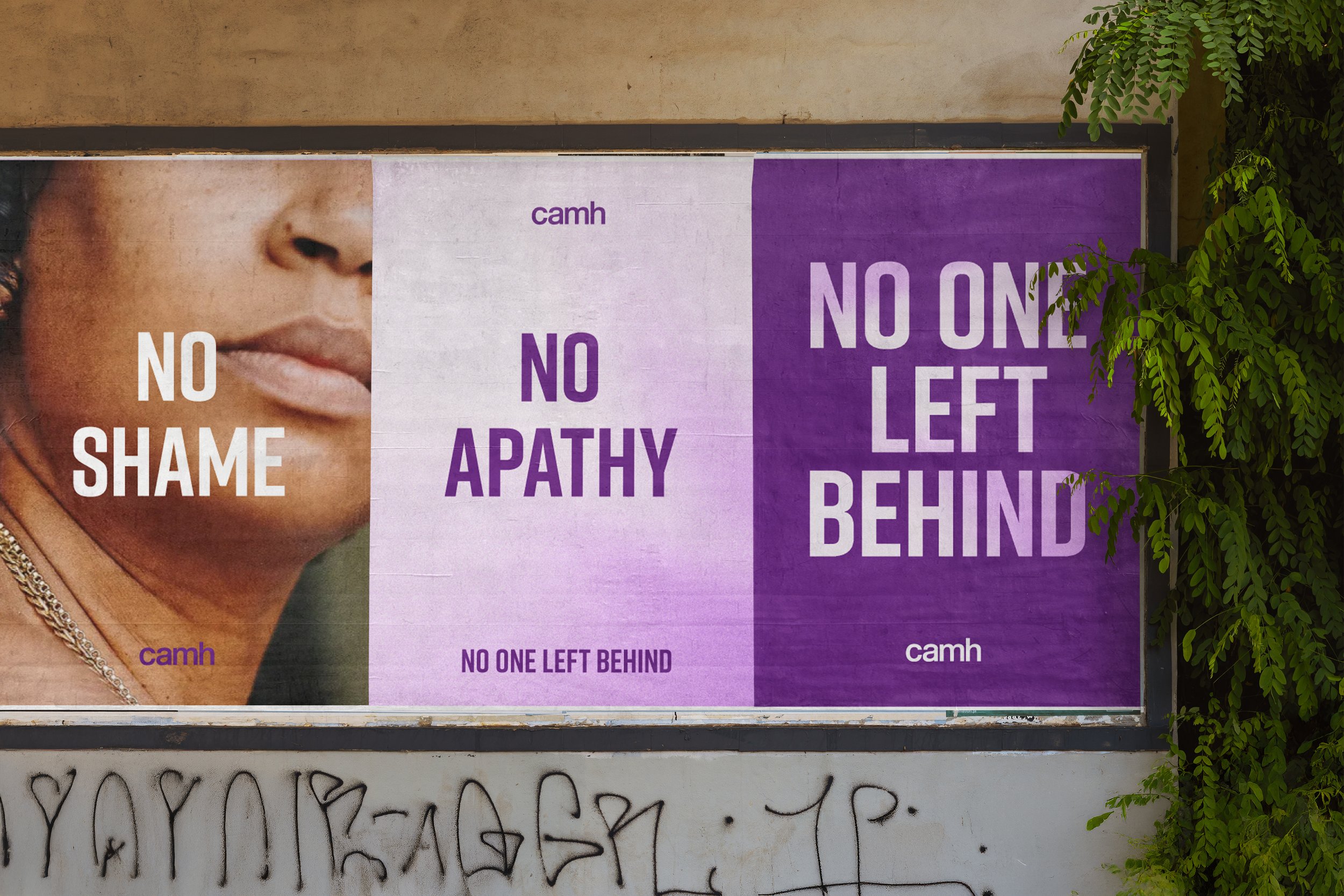 A billboard with a partial image of a woman's face on the left. The billboard has three sections with text: "No Shame" on the left, "No Apathy" in the middle, and "No One Left Behind" on the right. The rightmost section has large text "NO ONE LEFT BEHIND" on a purple background. The words "camh" appear in small purple letters in the upper left and lower right corners of the billboard. There is some graffiti or tagging below the billboard.