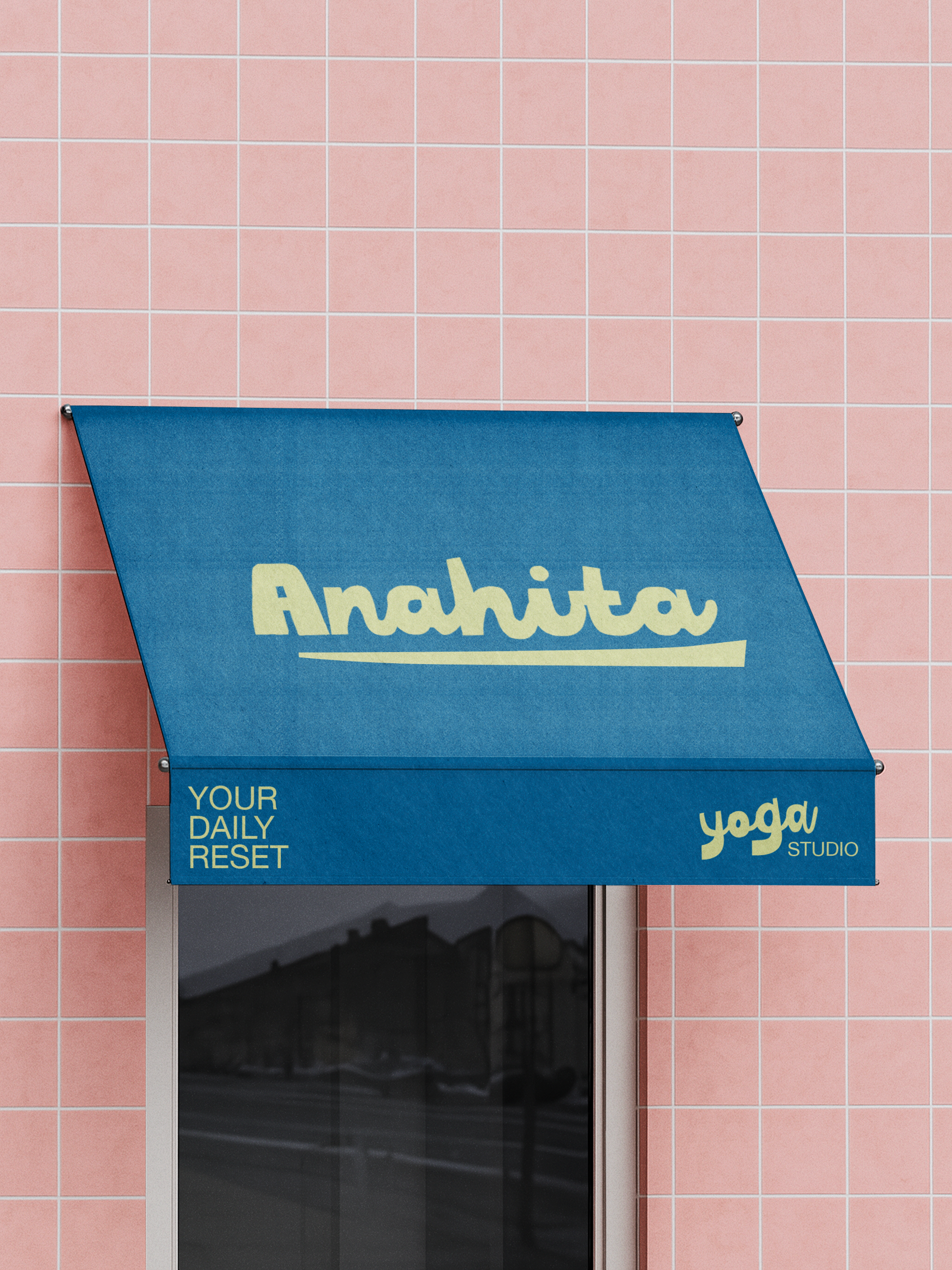 Tissu bleu avec l'inscription Anahita, studio de yoga, à l'extérieur d'un bâtiment avec des carreaux roses.