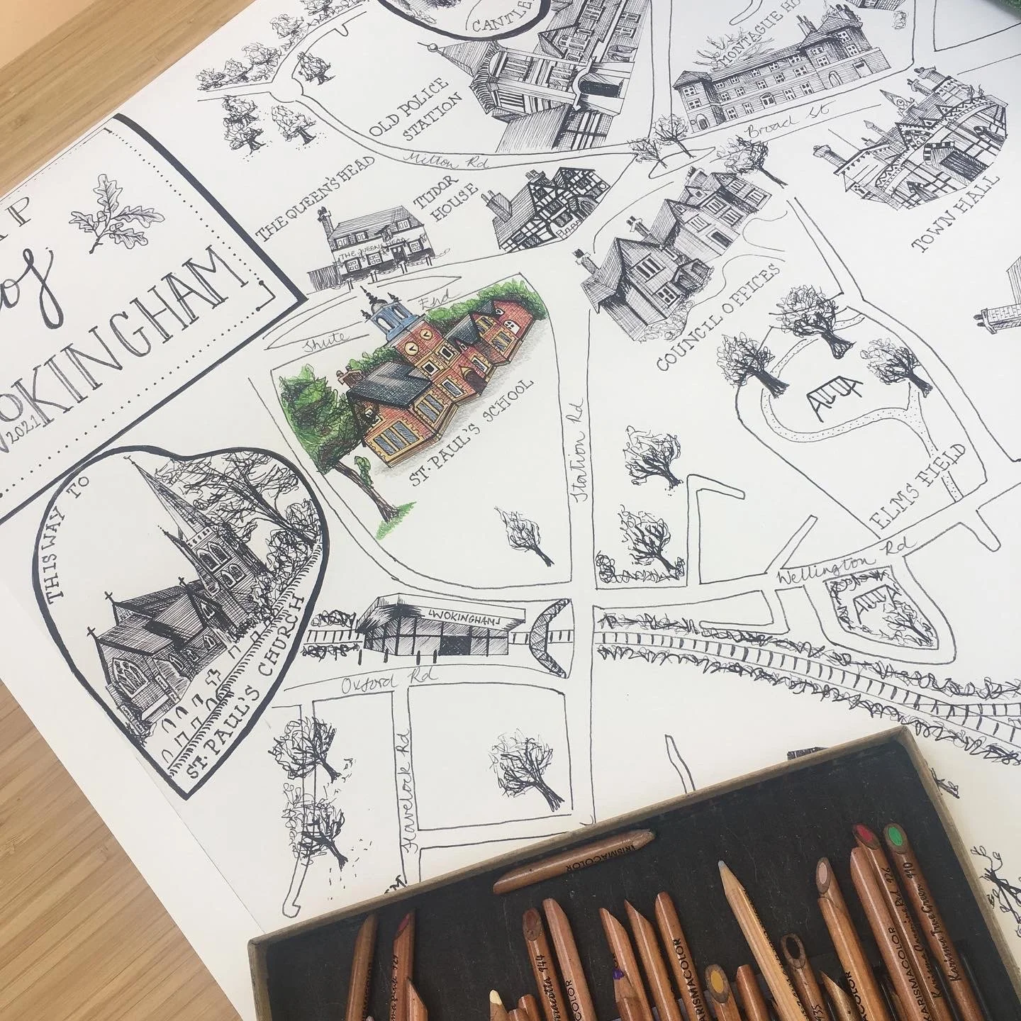 Close up of illustrated map of Wokingham, with St Paul's clock tower in colour. Set of pencils in foreground.