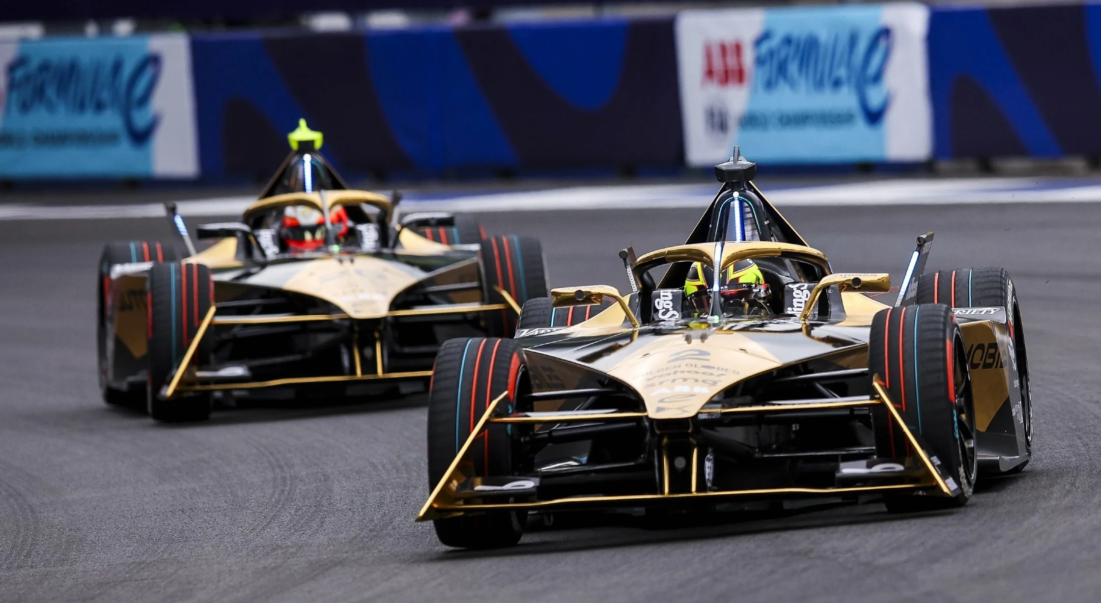 Two electric race cars competing in an ABB Formula E race.