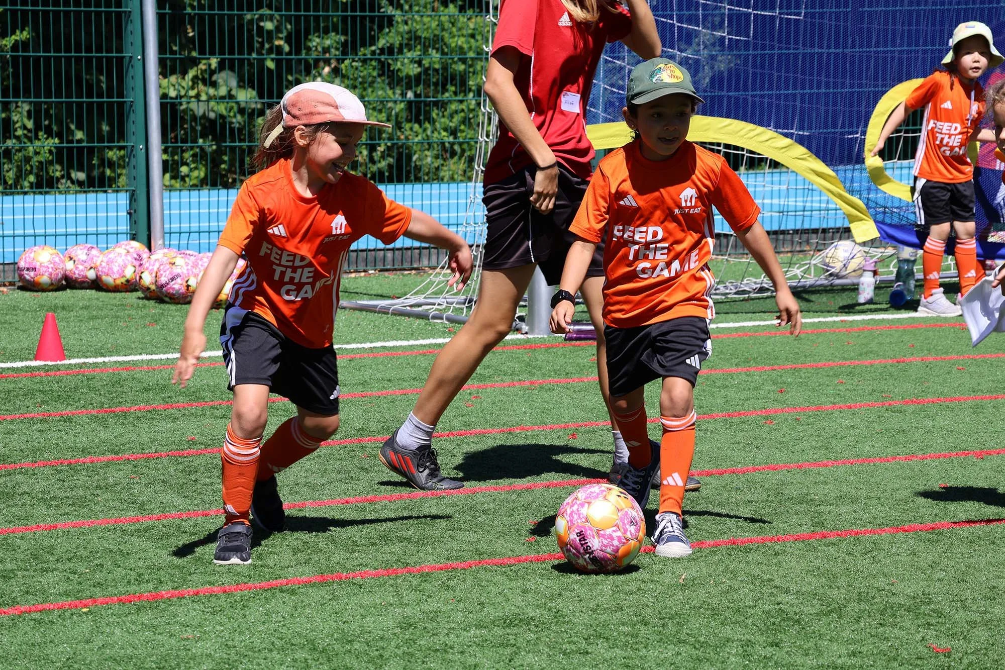 Two children enjoying playing football at Feed The Game camp