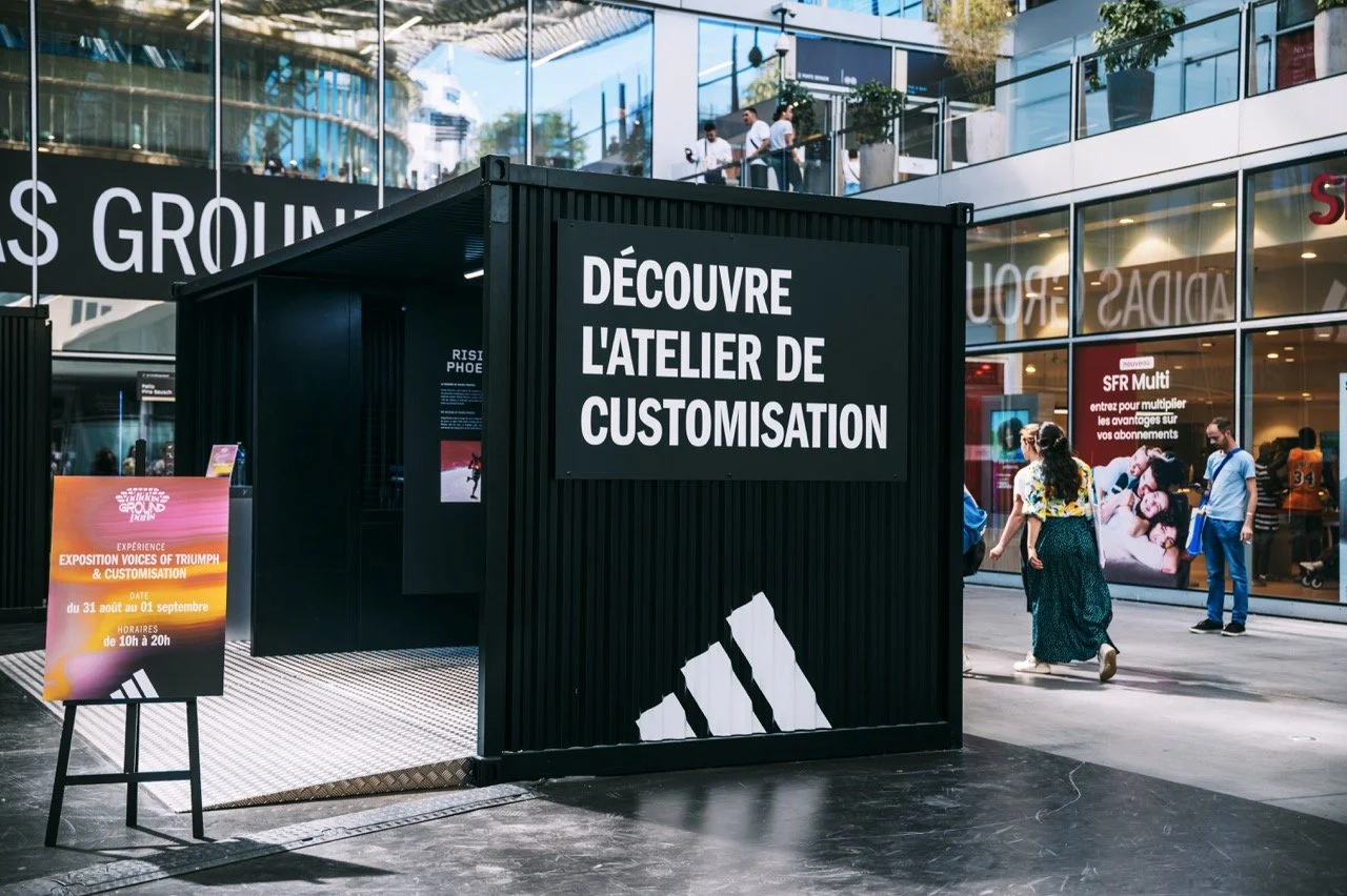 The exterior of the adidas Rising Phoenix activation at Paris 2024, reading 'DISCOVER THE CUSTOMIZATION STUDIO' in French 