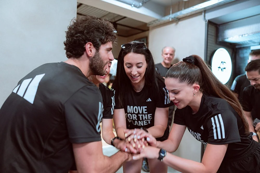 Group of four people during Move For The Planet eventunify their hands to celebrate the collaboration 