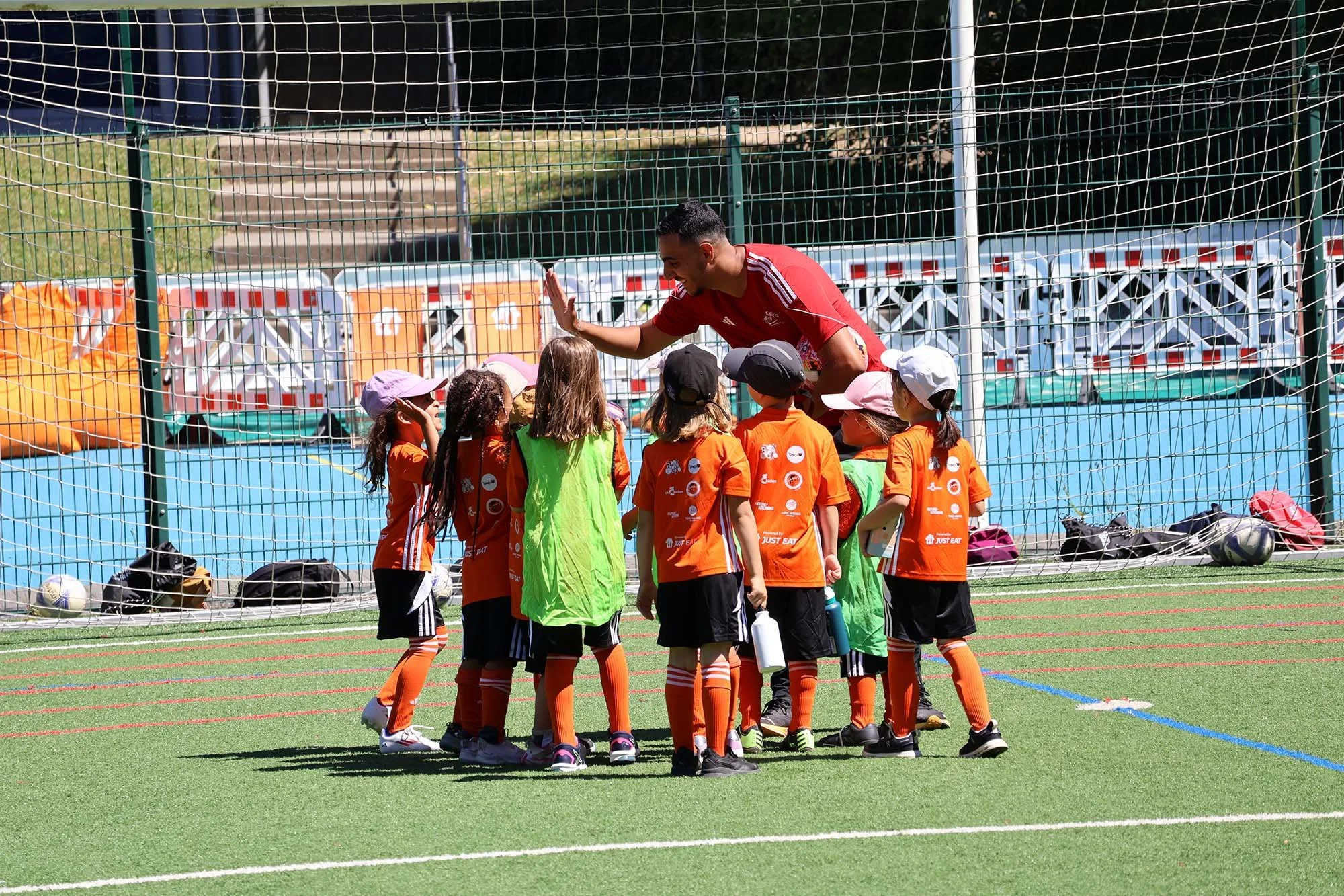 A coach gives a high five to girls at a Feed the Game camp.