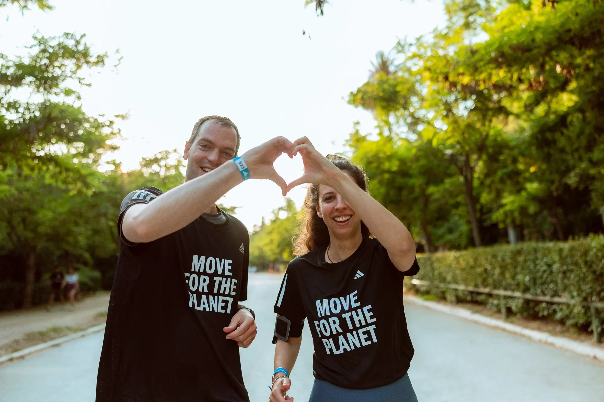 two runners at Move for the planet event create an heart unifying their hands