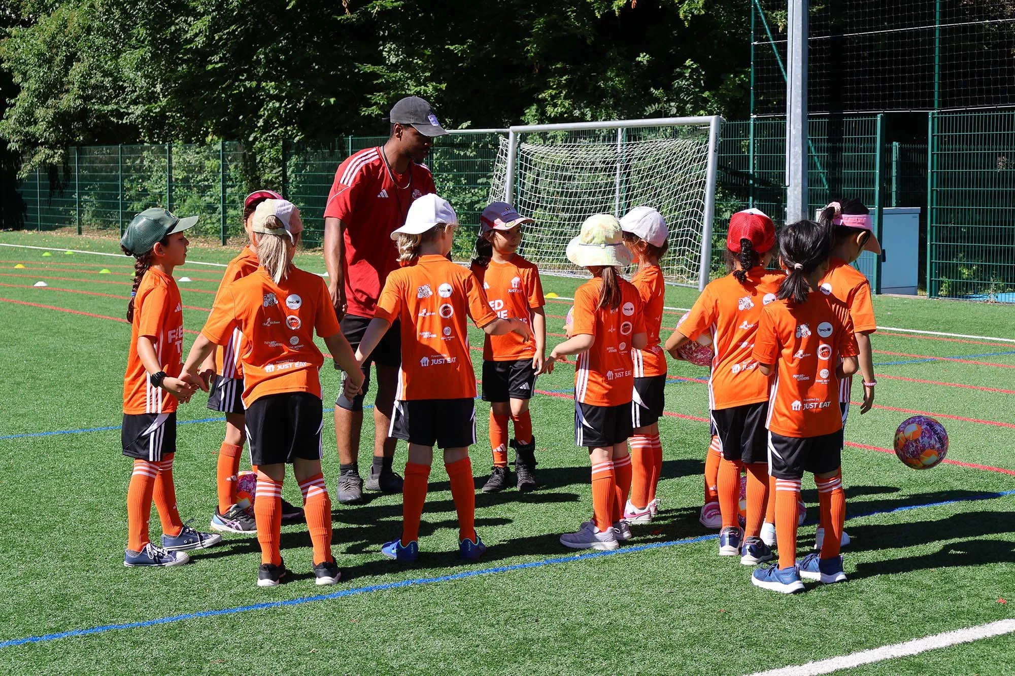 Coach and young players speaking at Feed The Game camps