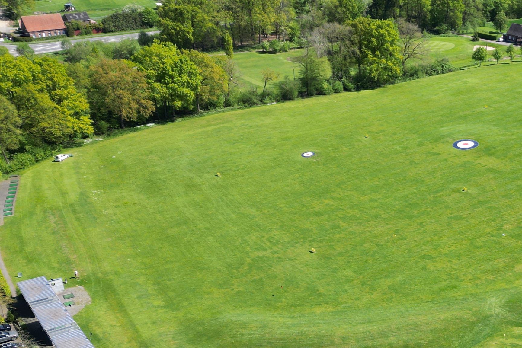 Golfplatz mit mehreren Zielzielen und Bäumen im Hintergrund.