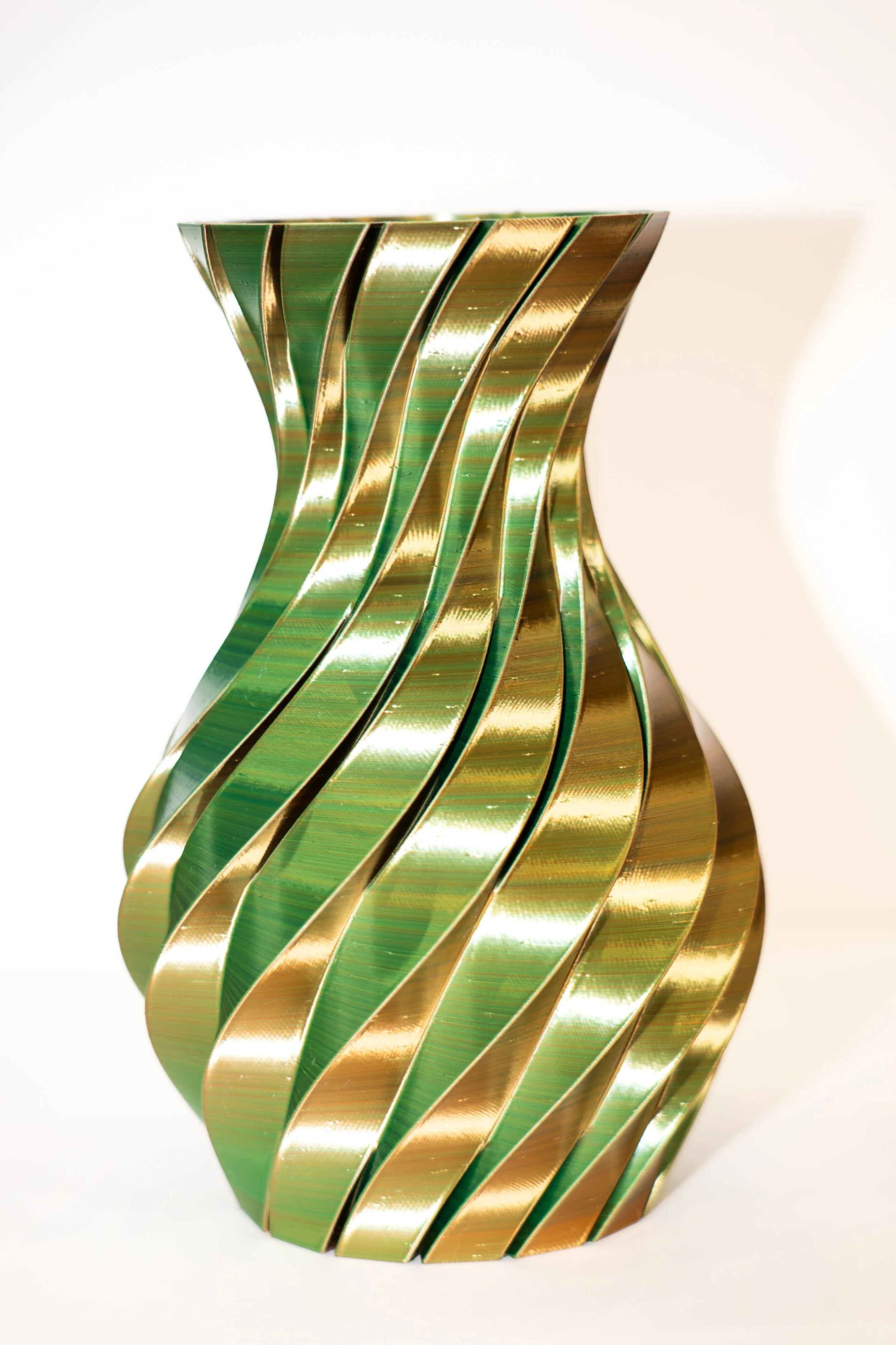 Decorative vase with gold and green wavy metallic stripes against a white background.
