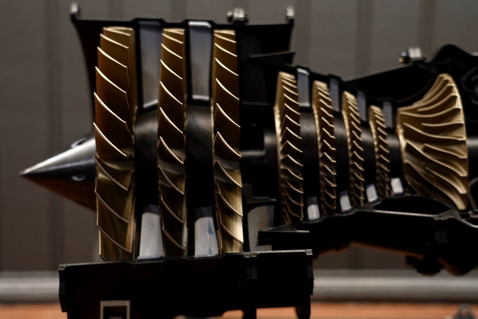 Close-up of a computer CPU cooler with gold-colored heat fins and a black fan frame, installed in a computer
