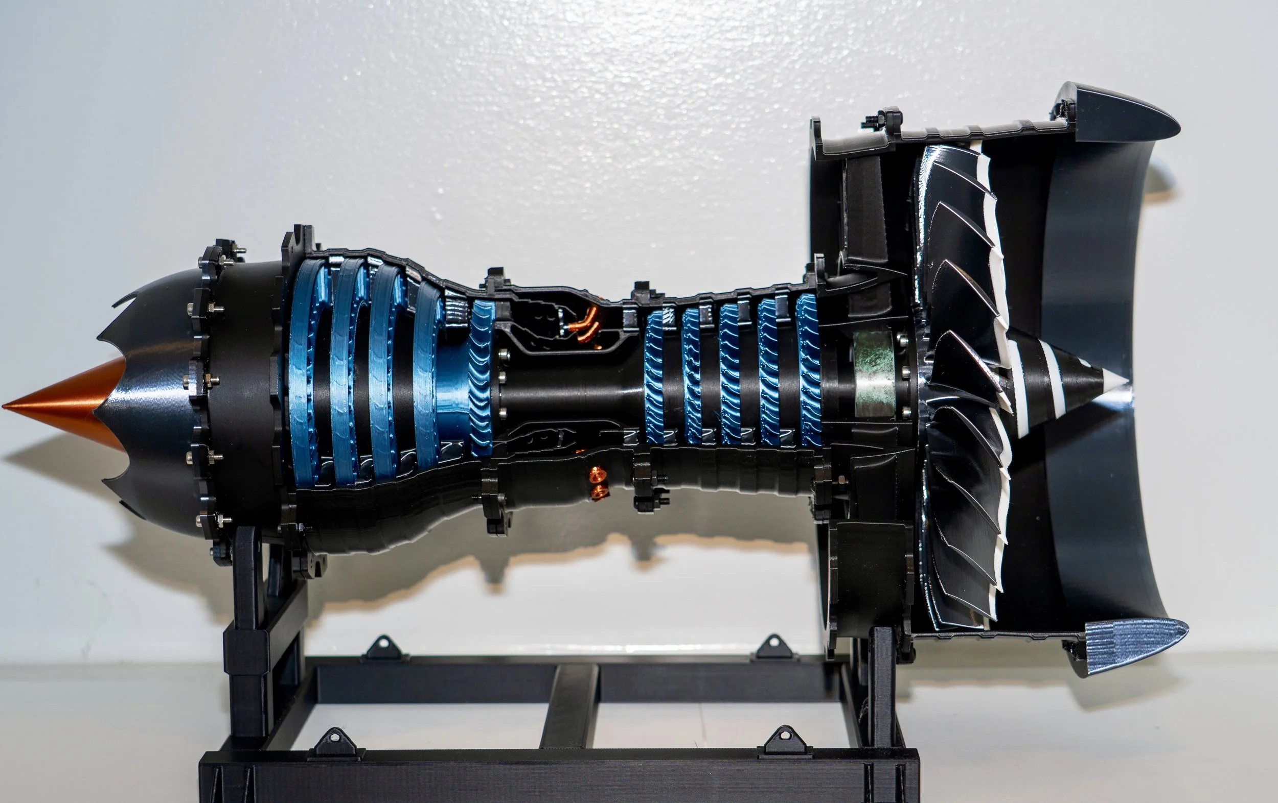 Cutaway model of a rocket engine showing internal components including turbines, combustion chamber, and nozzle.