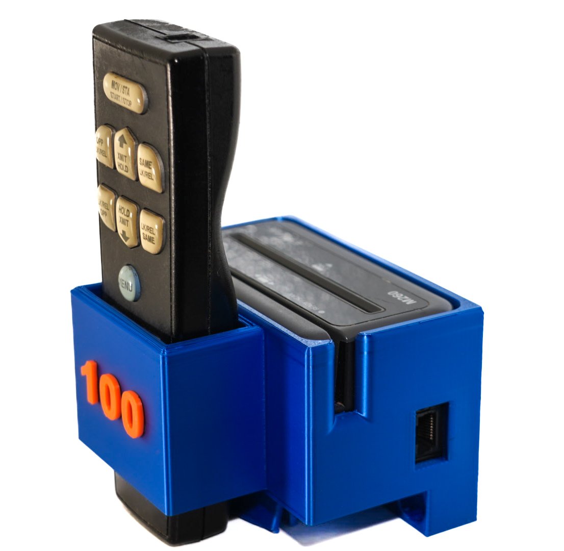 A remote control placed inside a blue holder with the number '100' in orange on it.