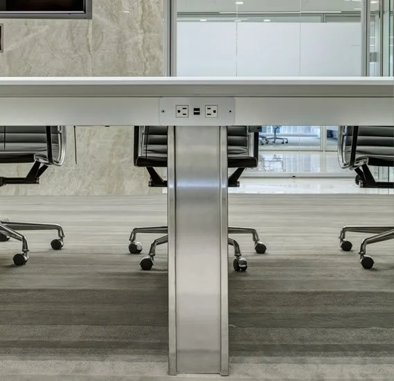 Close-up of conference room table showing the power options on the side of the table under the apron.
