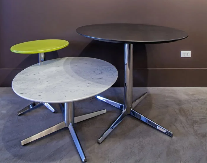 Three Asteri collaborative and cafe tables in various round dimensions, colours, and heights.