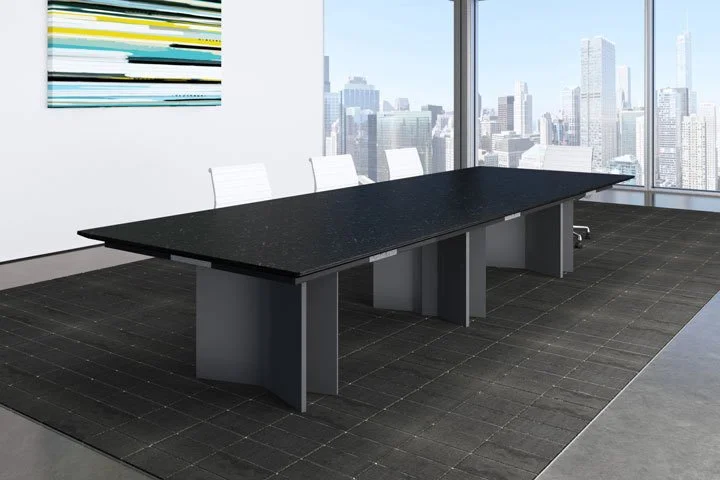 A modern conference room with a large black table, three white chairs, abstract artwork on the wall, and floor-to-ceiling windows showing a city skyline.