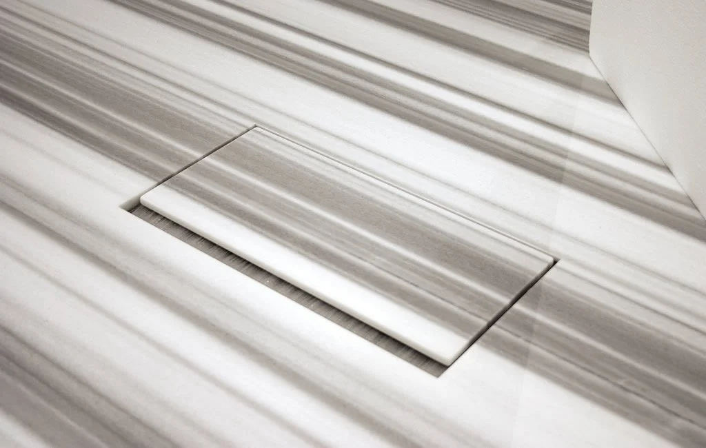 Close up of 2Merge collaborative and cafe table  showing matching natural stone power option flip-up door.