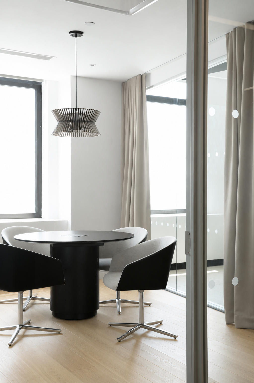 Small meeting room with a Drum meeting table with black round table top and matching black Drum base.