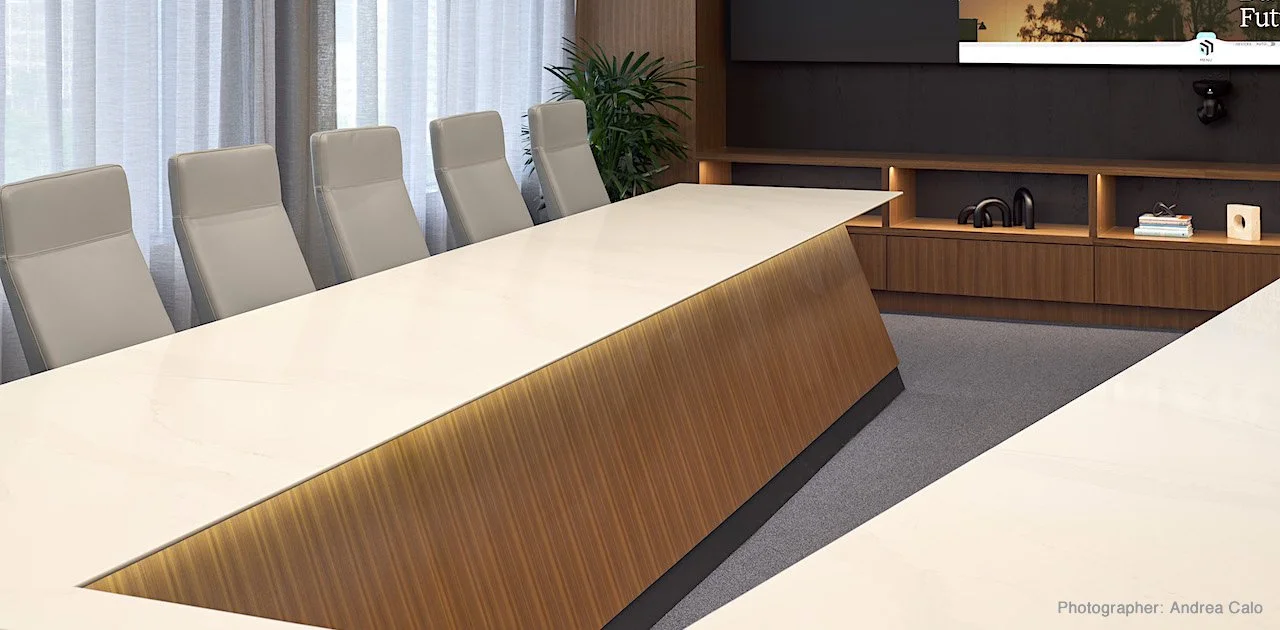 V-shaped conference table with natural stone table top and wood veneer modesty panels.