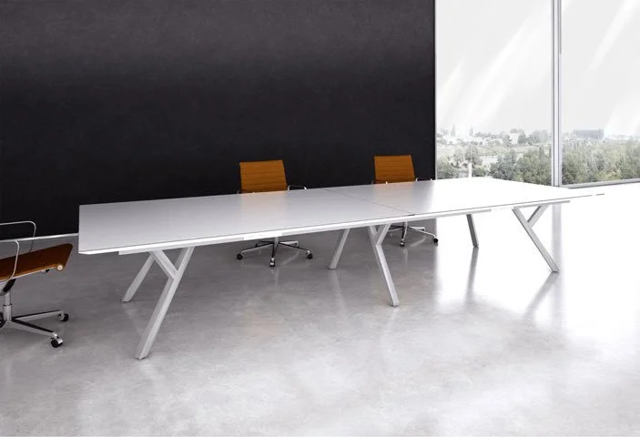 Long 2Merge table with white table top, chrome base and three chairs.