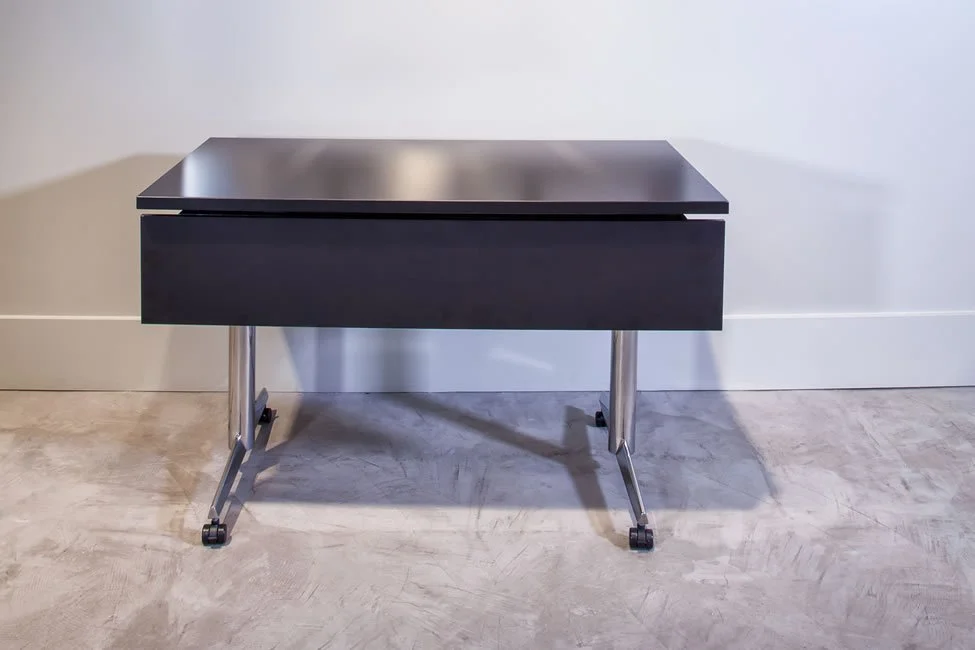 Asteri training table with dark wood veneer tabletop and a chrome base.