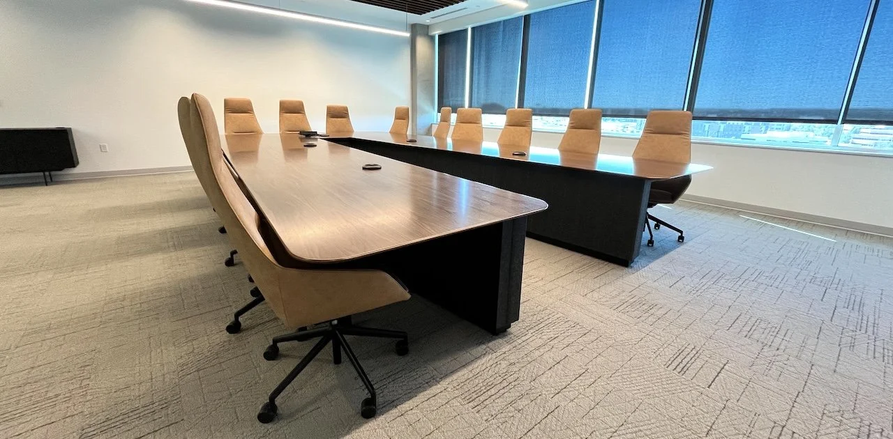 V-Shaped conference room table with wood veneer tabletop and black modesty.