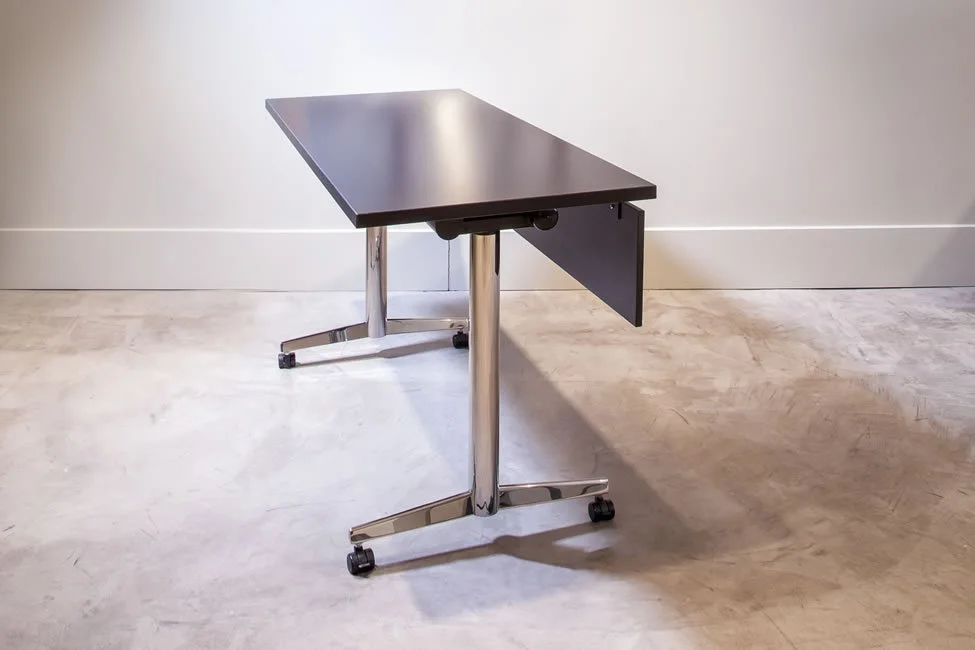 Asteri training table side view with dark wood veneer tabletop and a chrome base.