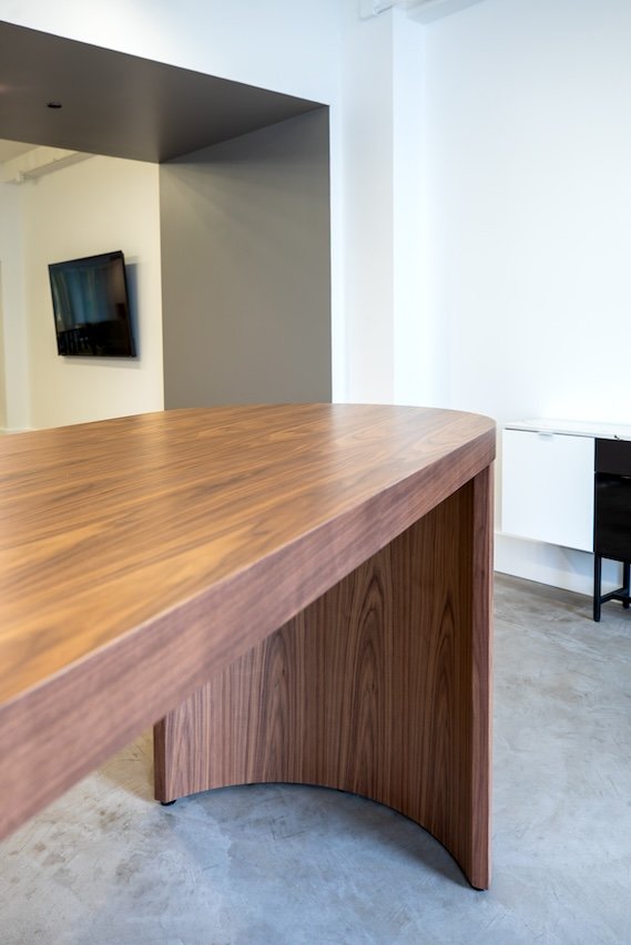 Crescent community table in wood veneer.