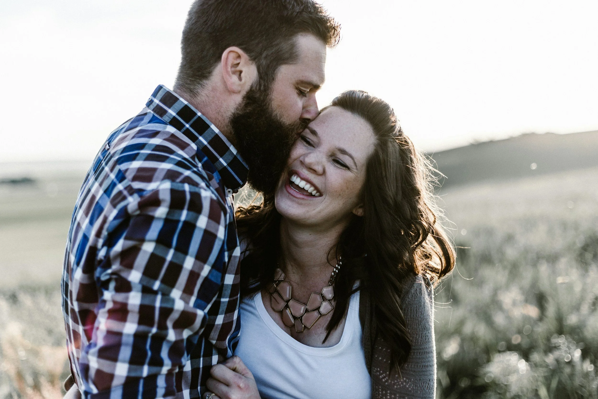 A couple kissing after working to move from emotional unavailability to reconnection after marriage counseling in Raleigh, NC