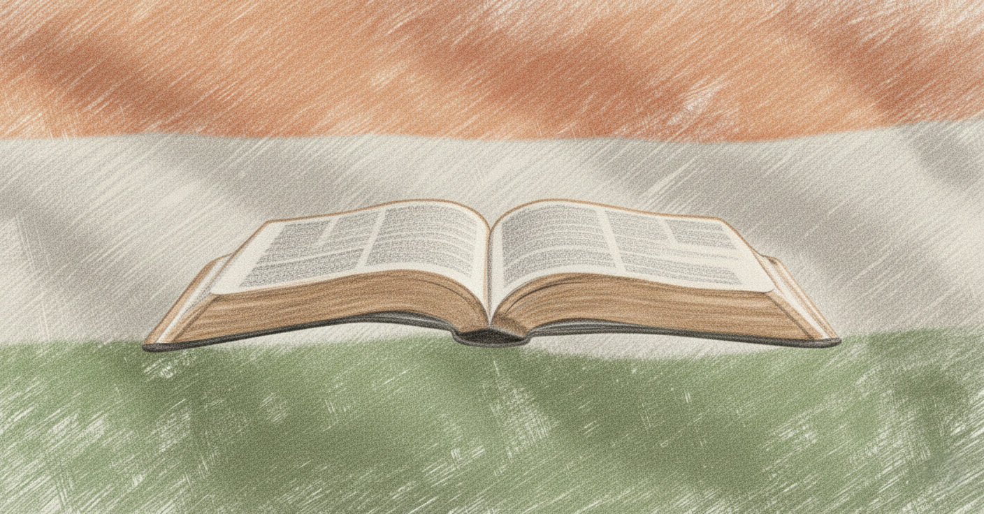 An open book resting on a green surface with a blurred flag in the background.