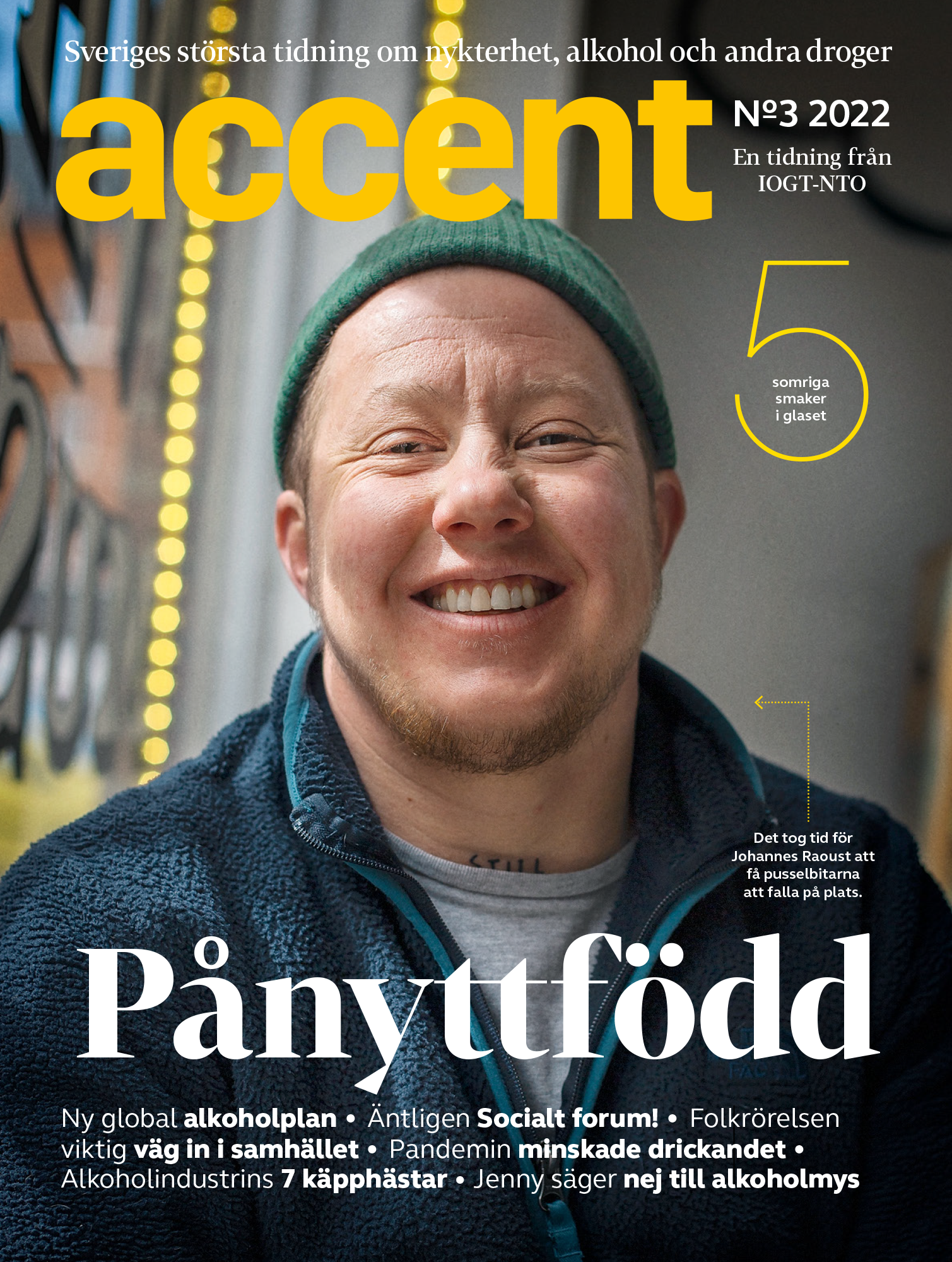 Close-up of a smiling man wearing a green beanie and a dark blue fleece jacket, on the cover of a Swedish magazine titled 'Accent' with headlines about alcohol, society, and health.