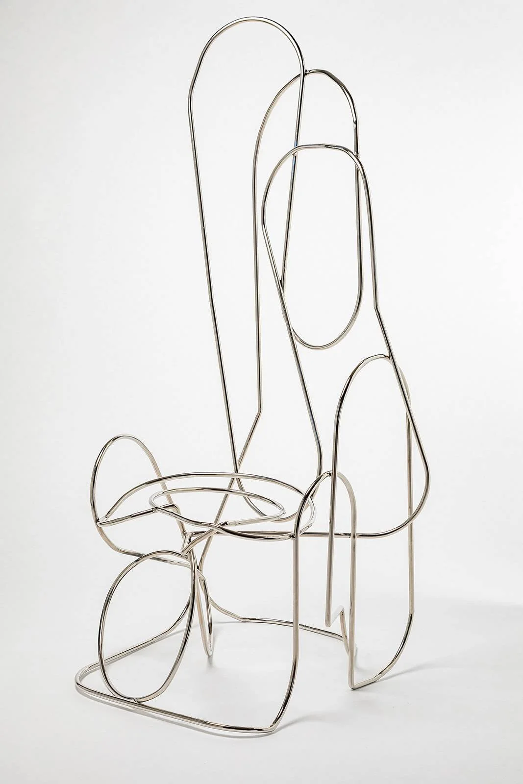 A modern chair frame made of metal wire with a minimalist, artistic design.