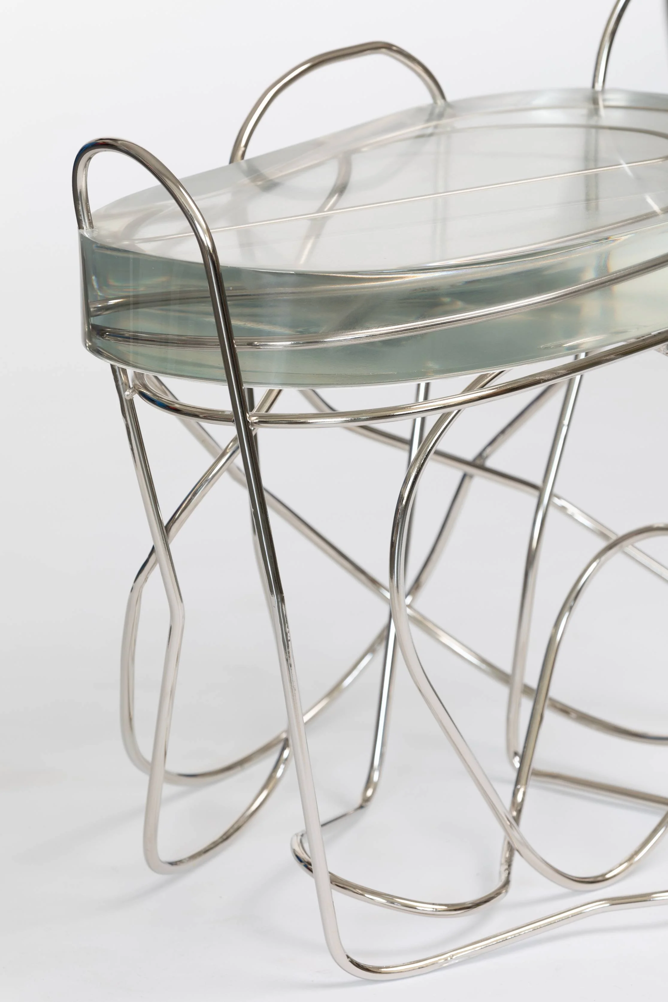 A clear glass tray supported by a silver metal wire stand.