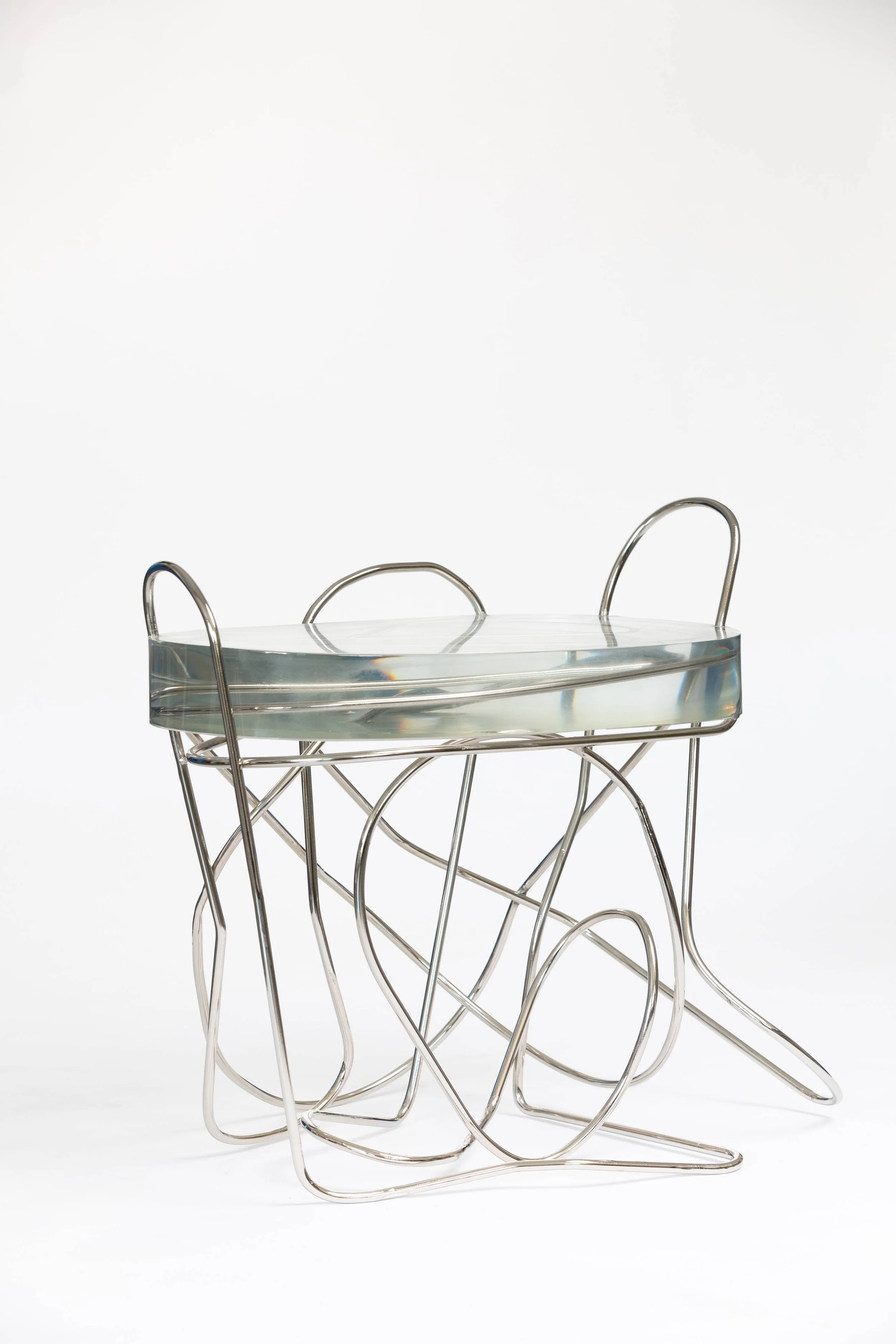 Modern table with a glass top and an abstract metal wire base, isolated on white background.