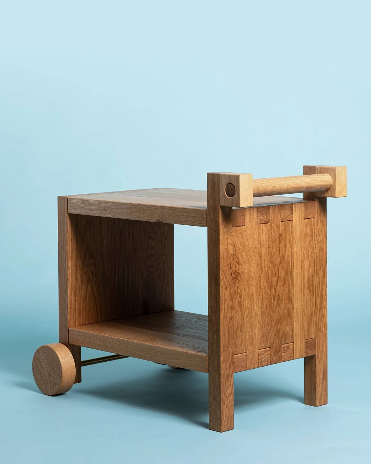 A wooden cart with two wheels on a blue background