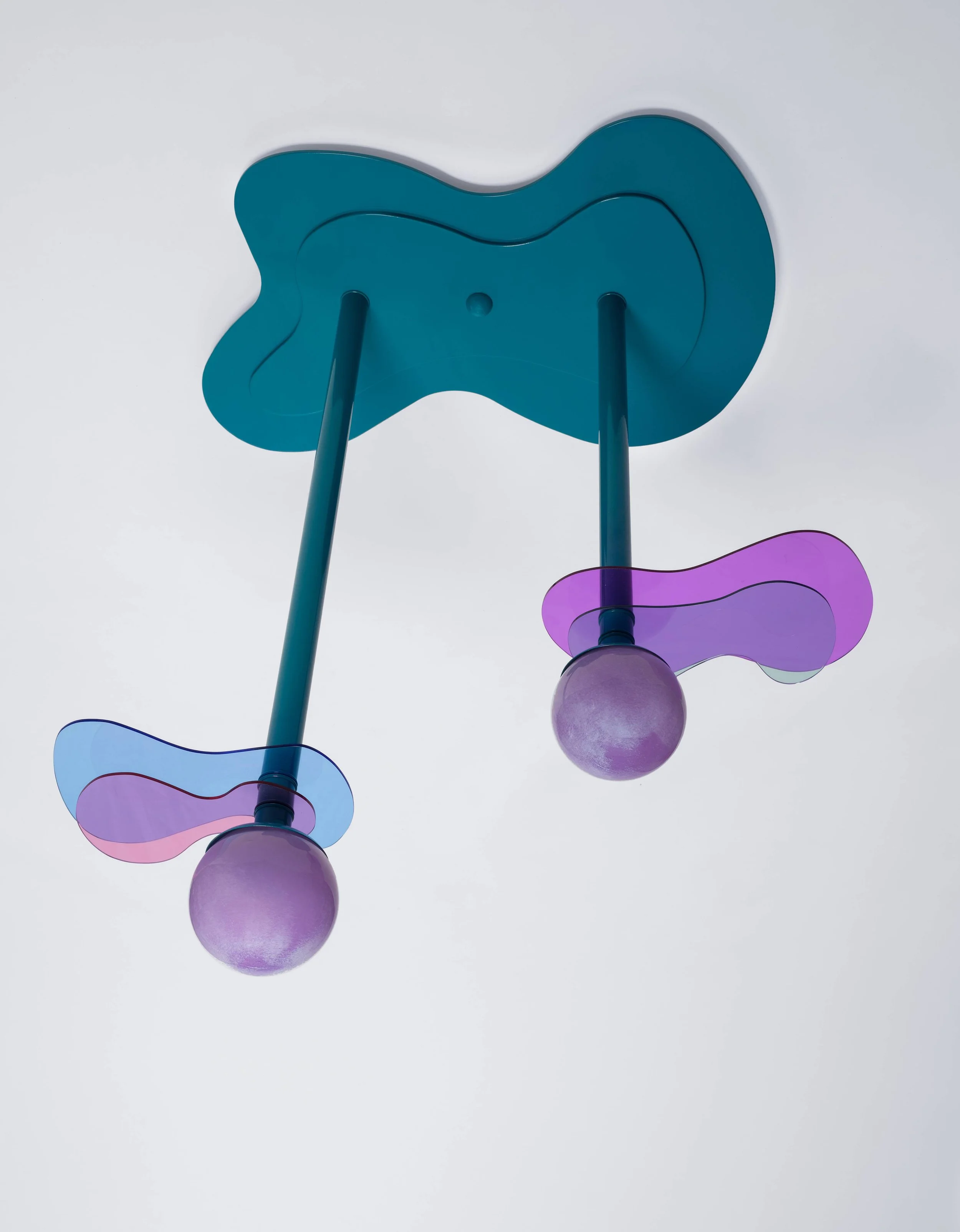 Modern ceiling light fixture with two purple glass globes and abstract colorful shades against a white ceiling.