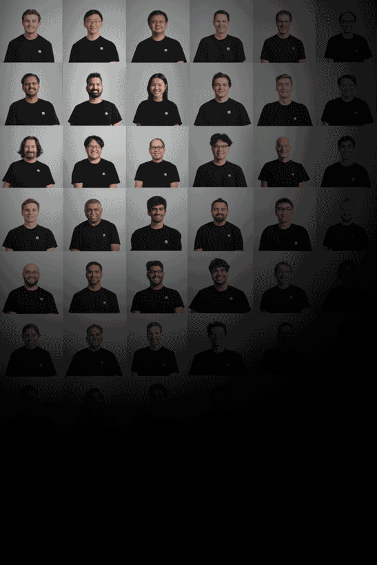 A collage of headshots featuring diverse men, all wearing black shirts, arranged in five rows and six columns, with a gradient background fading from light gray at the top to black at the bottom.