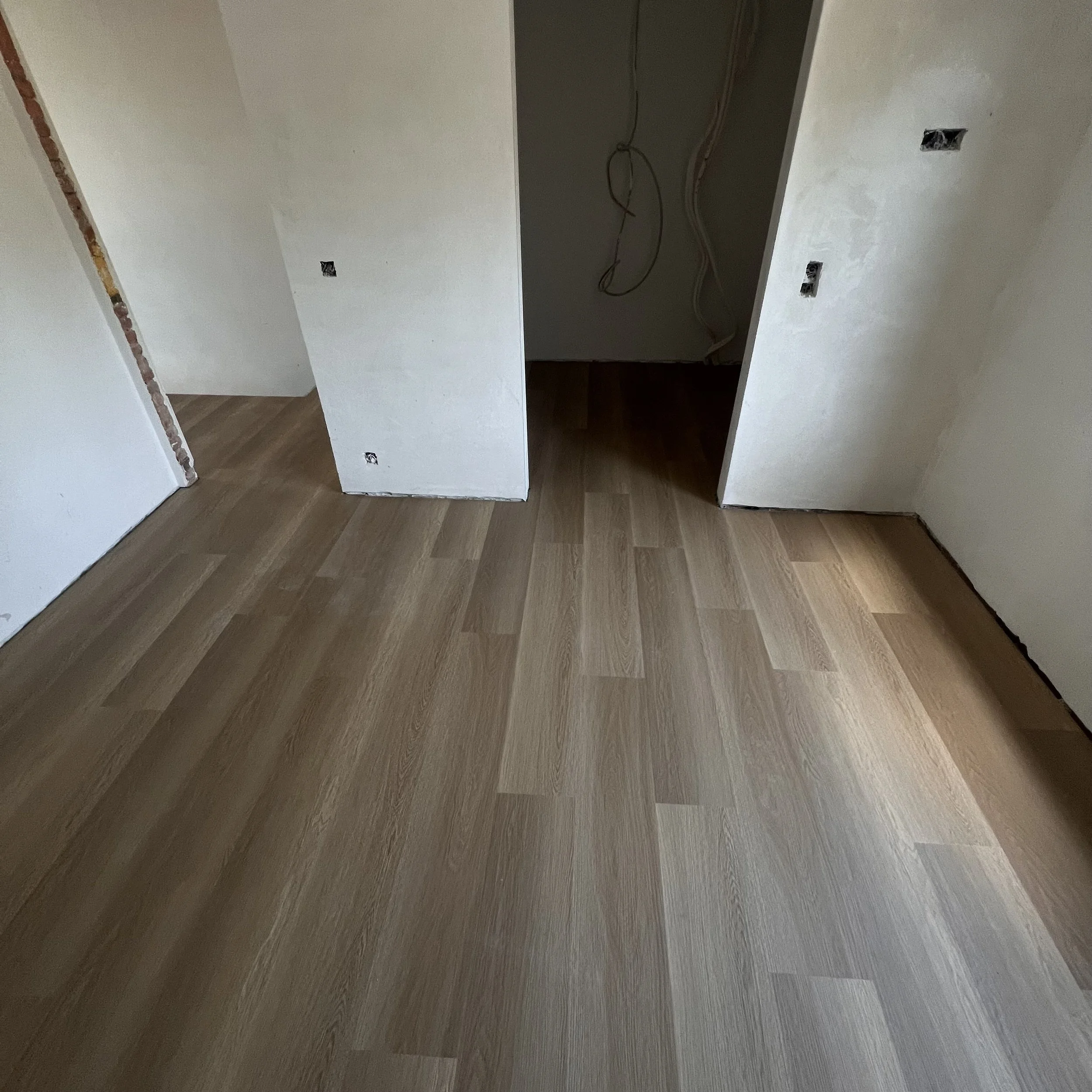 Binnenkamer met een nieuw gelegde laminaatvloer.