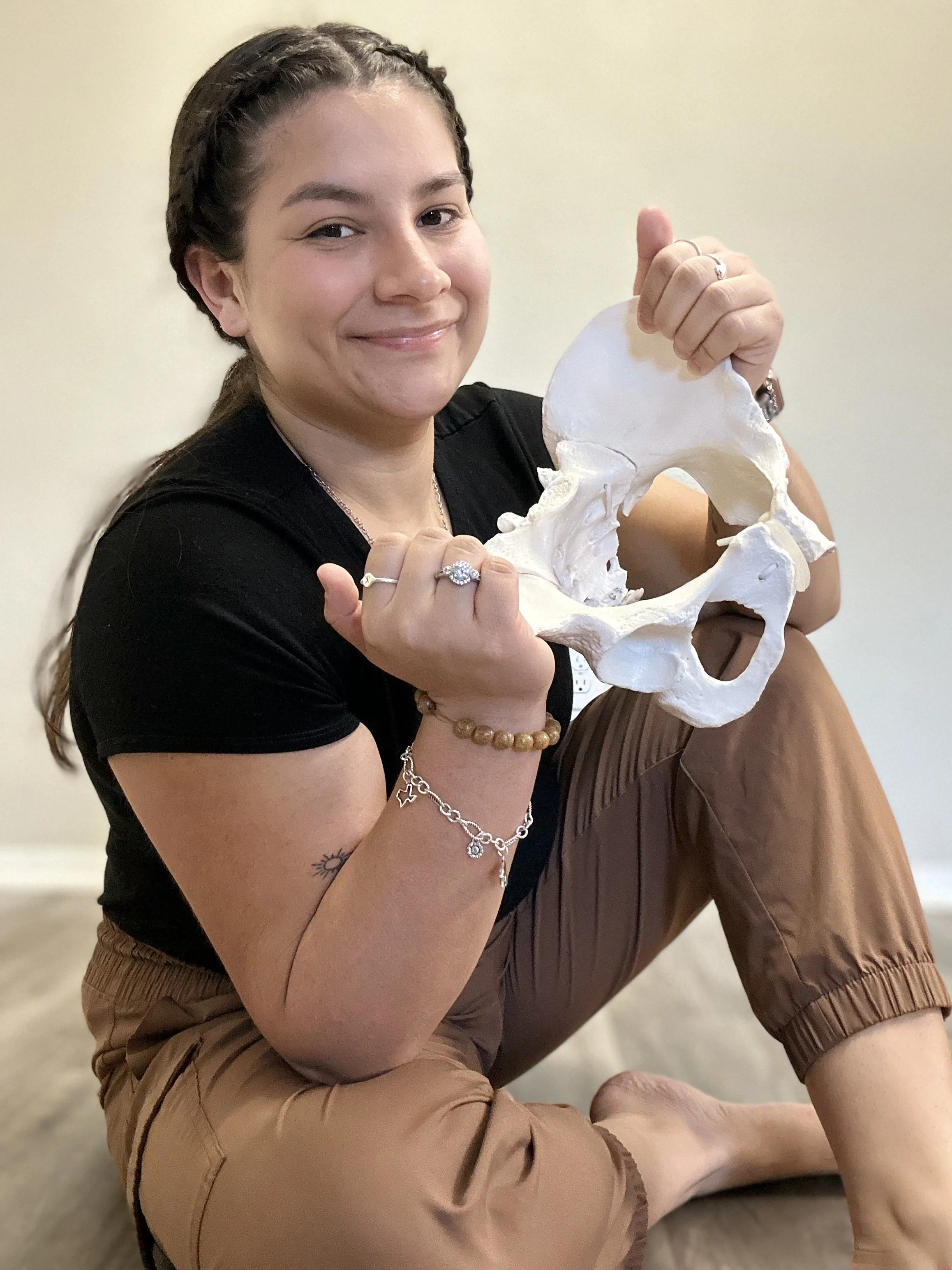 Krissa The Doula holding a pelvis for childbirth education classes for birth doula support and postpartum support in central texas waco texas