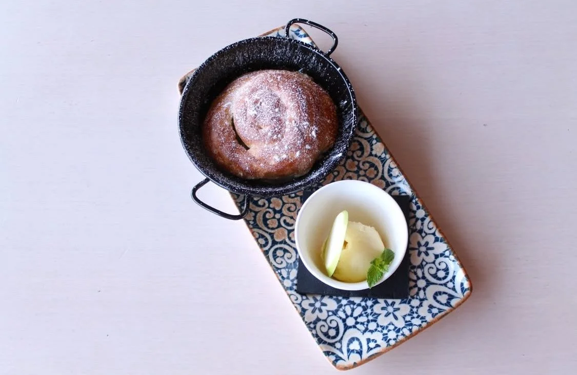 Ensaïmada rellena de manzana, al horno y presentado con helado.