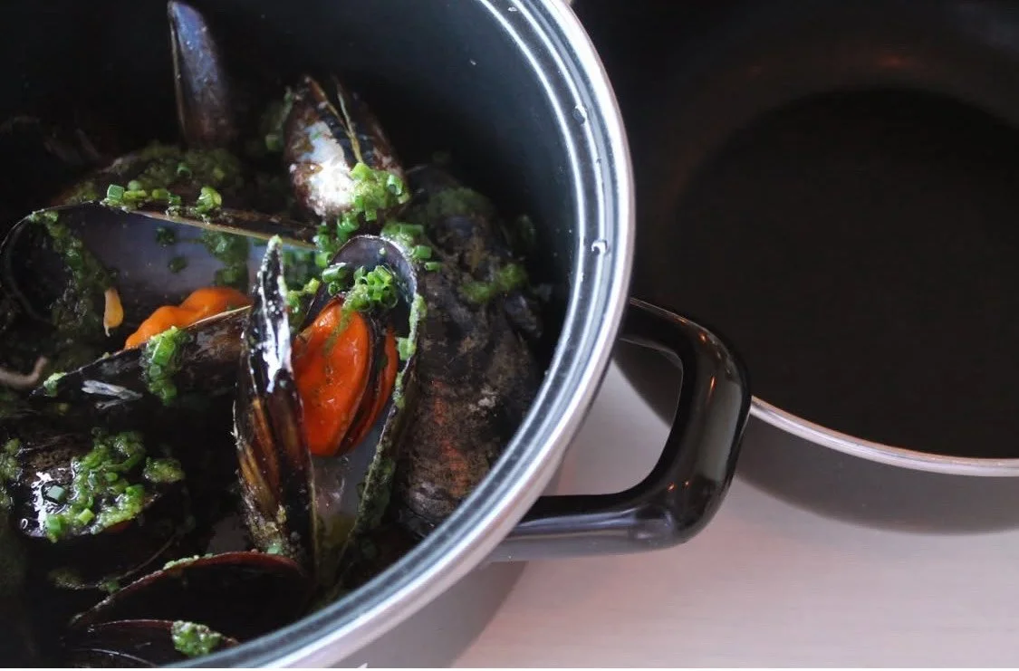 Mejillones al ajillo en una olla con perejil, lista para servir.