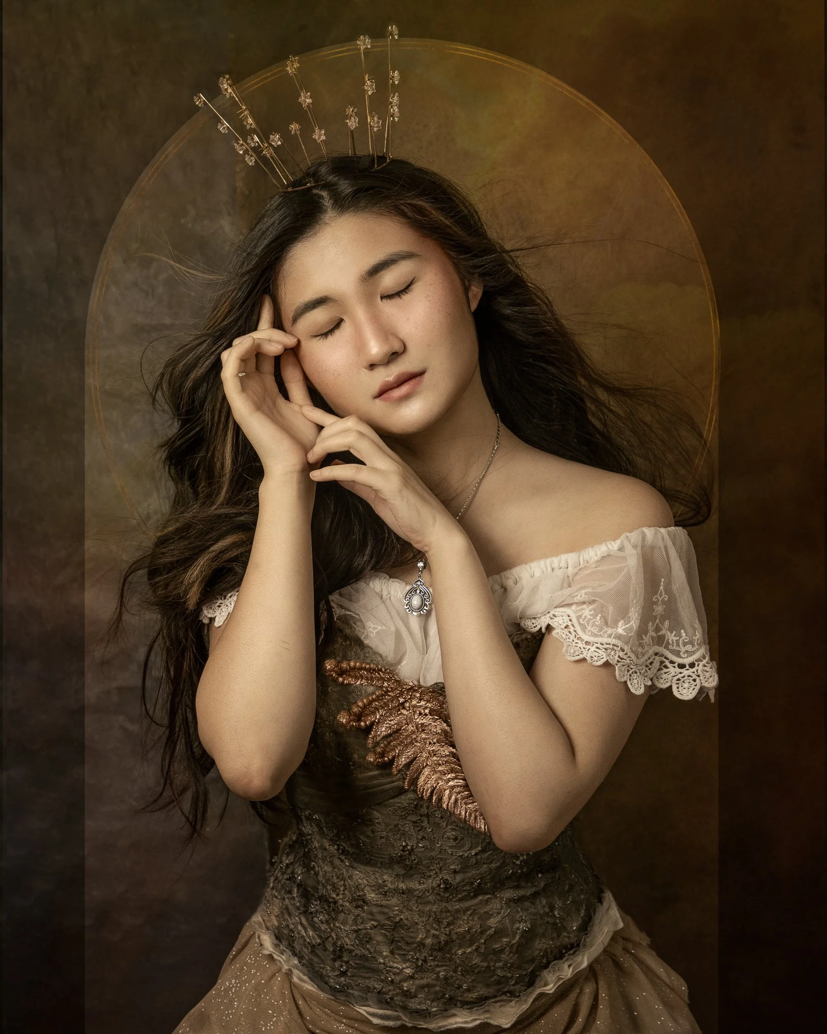 A woman with long dark hair and closed eyes, wearing a lace dress and a pendant necklace, with a decorative headpiece, posing against a dark brown background with a circular glow.tarot card by Karolina Skorek