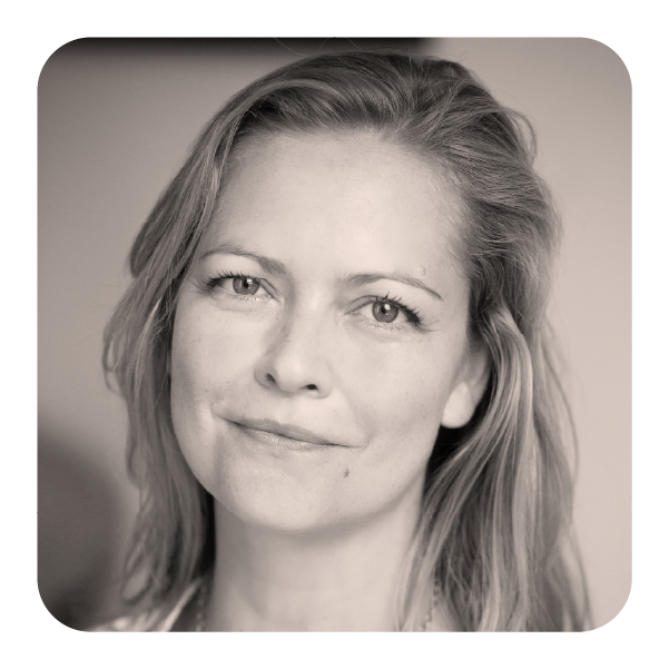 Black and white portrait of a woman with wavy hair smiling gently.
