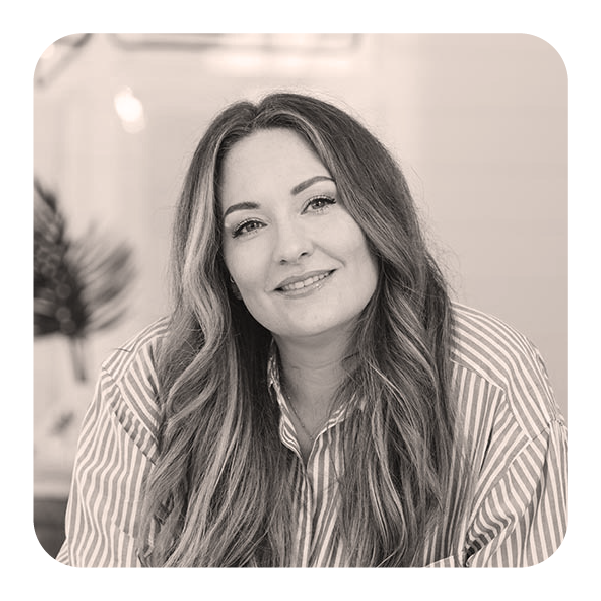 A woman with wavy hair wearing a striped shirt, smiling at the camera.