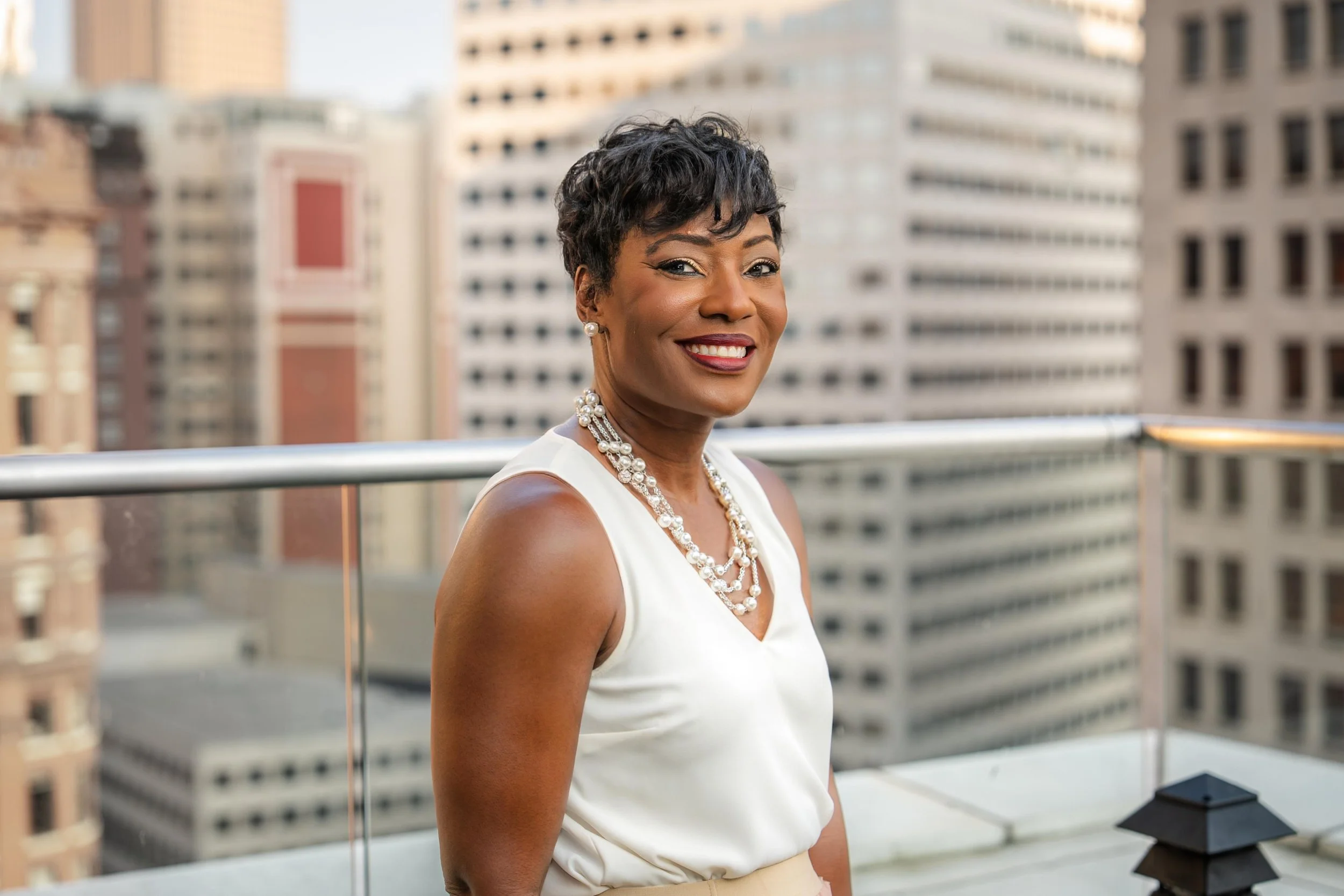 Kenya S. Manning, MBA, SHRP, SHRM-SCP, standing on a rooftop with a cityscape in the background.