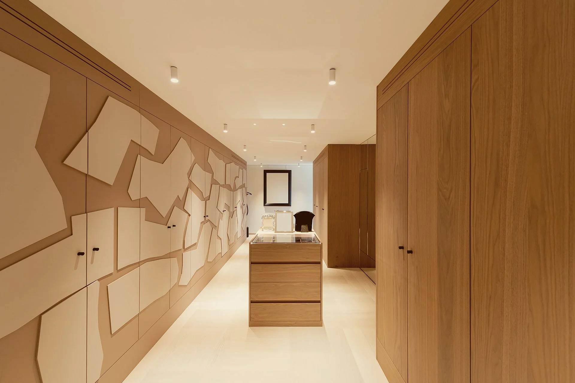 Intérieur d'une pièce moderne avec murs en bois, un meuble central en bois avec un plateau en verre, et une décoration murale abstraite.